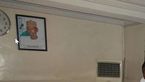 A reception area with a tiled counter, a framed portrait on the wall, and an air conditioning unit. - Rendezvous Hotel (Abuja)