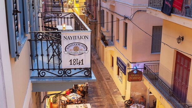 Kapea katu, jonka varrella on rakennus, jossa on kyltti, jossa lukee ”NAYTIAION 1841” ja ”HOTEL AOHNA”.