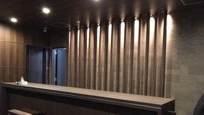 Un área de bar moderna con una barra larga y dos taburetes.