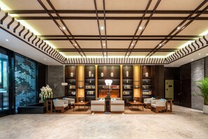 A modern lobby with a central seating area, bookshelves, and a decorative wall. - SSAW Boutique Hotel Liuzhou Garden (Liuzhou)