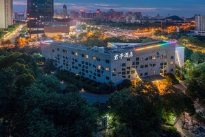 A hotel with a modern architectural design, surrounded by trees and urban landscape. - SSAW Boutique Hotel Liuzhou Garden (Liuzhou)