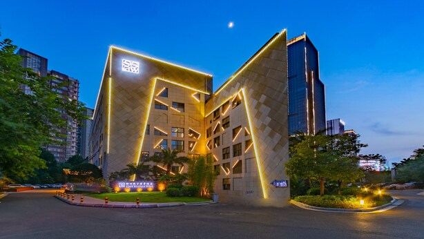A modern hotel with a distinctive geometric facade and illuminated signage. - SSAW Boutique Hotel Liuzhou Garden (Liuzhou)