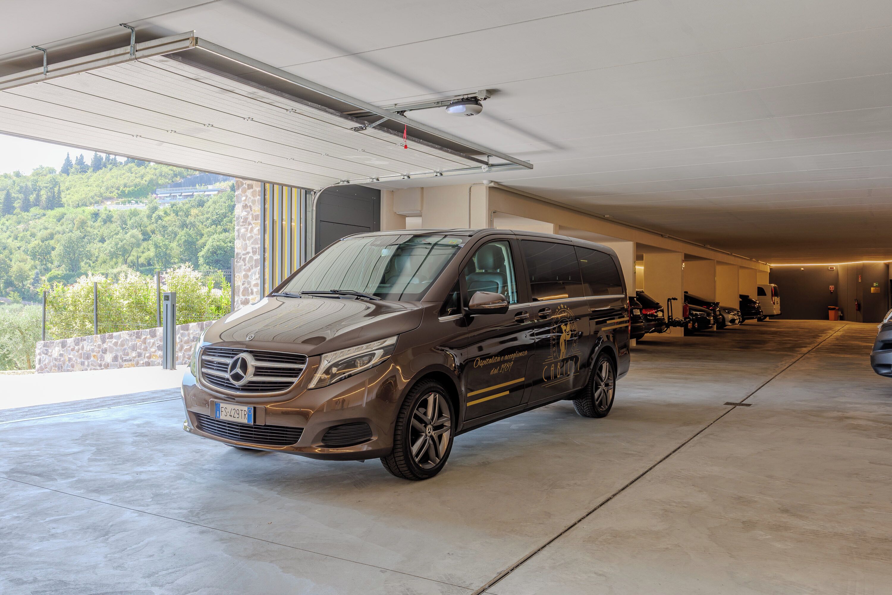 Un garaje espacioso con una furgoneta Mercedes-Benz Sprinter estacionada.
