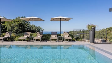 Piscine extérieure, parasols de plage, chaises longues