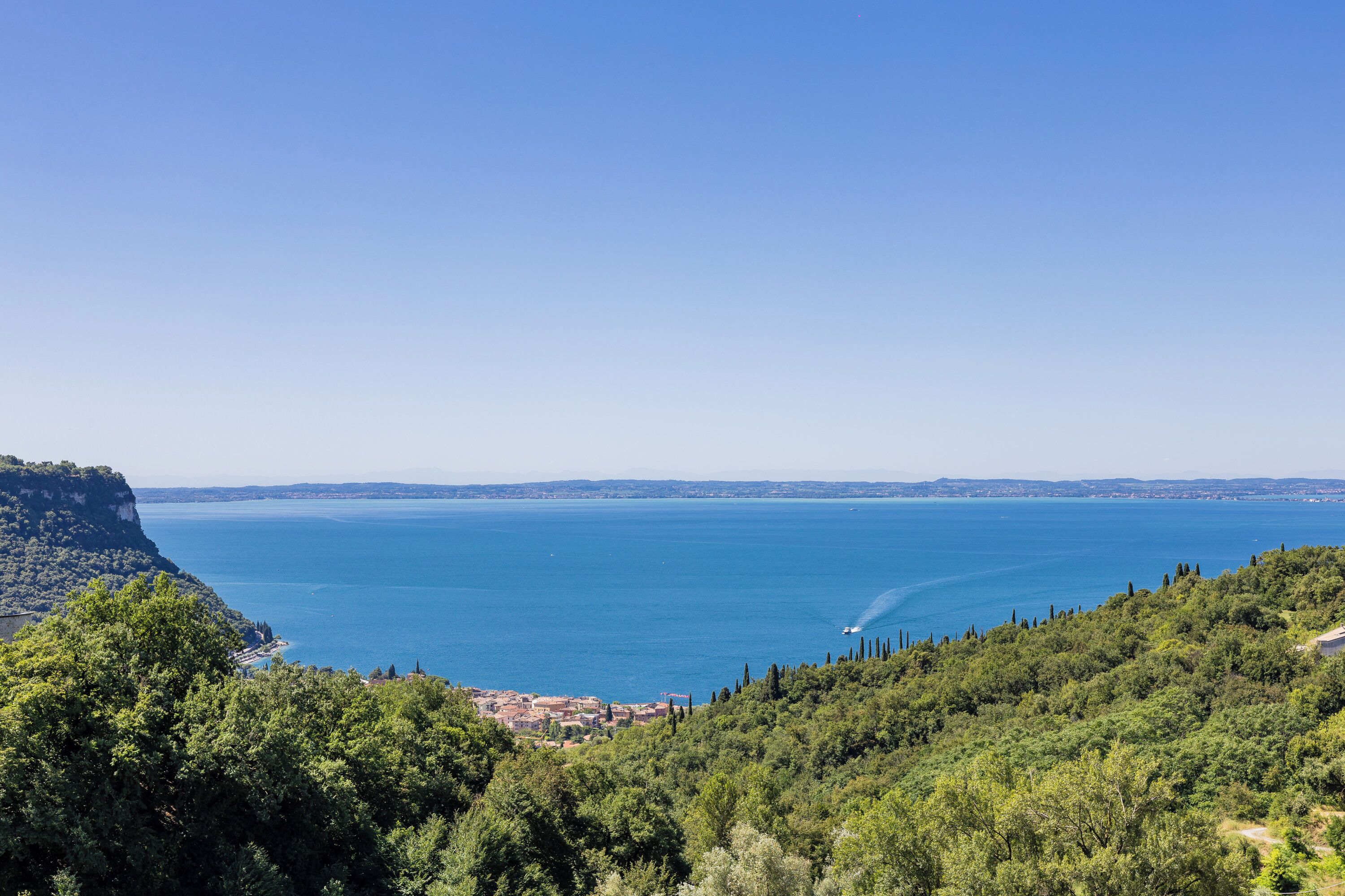 Eine Küstenlandschaft mit Blick auf eine Stadt, eingebettet zwischen Hügeln und dem Meer.
