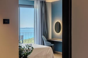 Una habitación de hotel moderna con balcón, escritorio y cama.