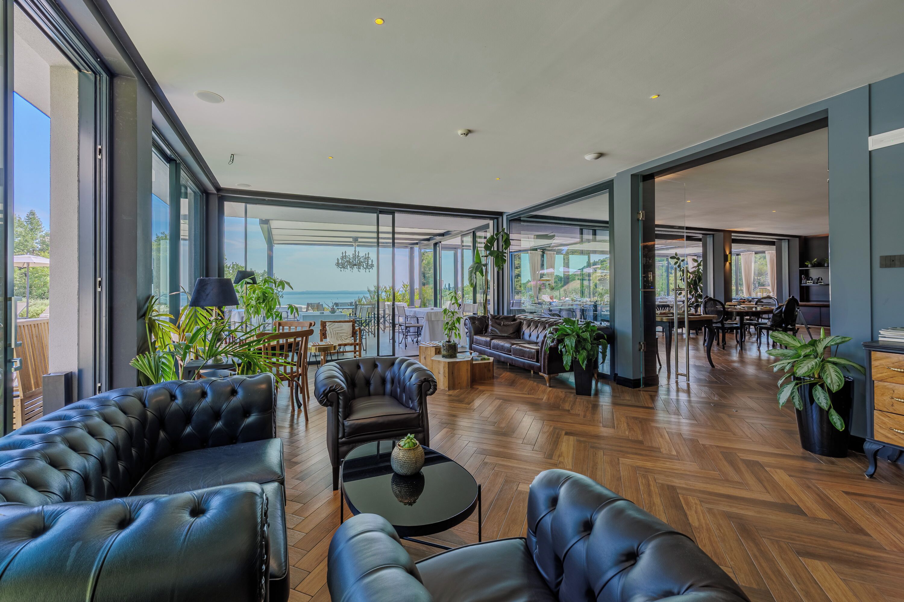 A spacious living area with leather sofas, a coffee table, and a view of the ocean.