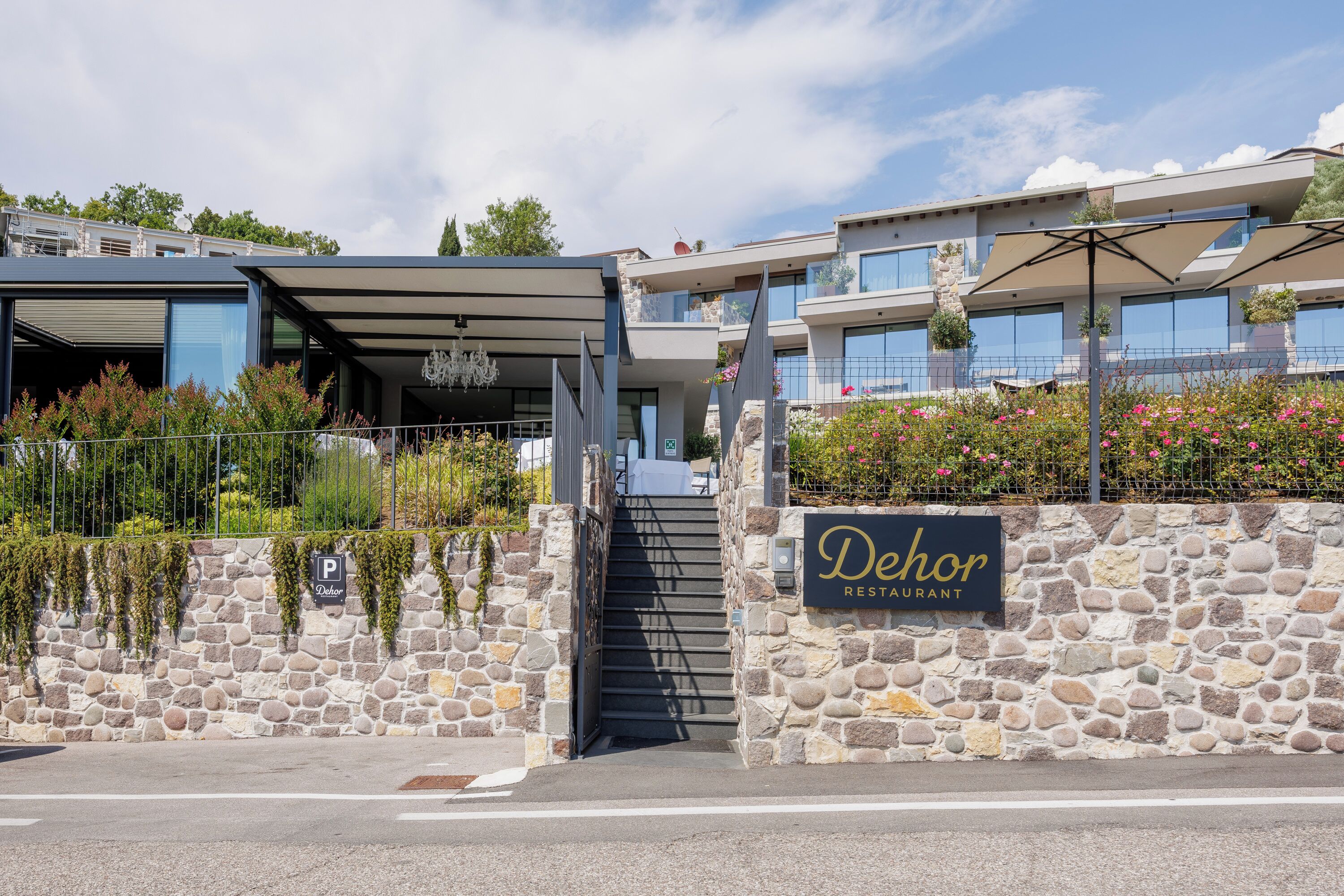 A stone wall entrance to a restaurant with a staircase leading up.