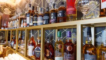 A variety of liquor bottles displayed on shelves in a bar setting.