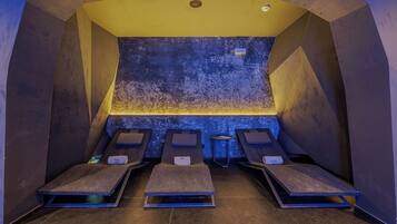 A sauna room with four benches, a textured wall, and a yellow ceiling.
