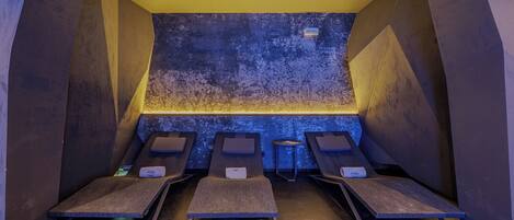 A sauna room with four benches, a textured wall, and a yellow ceiling.