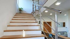 Una escalera de madera con barandilla de metal que lleva a una plataforma.