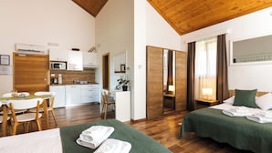 Una habitación de hotel con dos camas, un kitchenette, una zona de comedor y un baño.