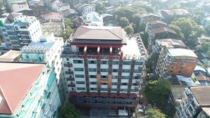 Un hotel con fachada roja y blanca, varios balcones y un techo rojo central.
