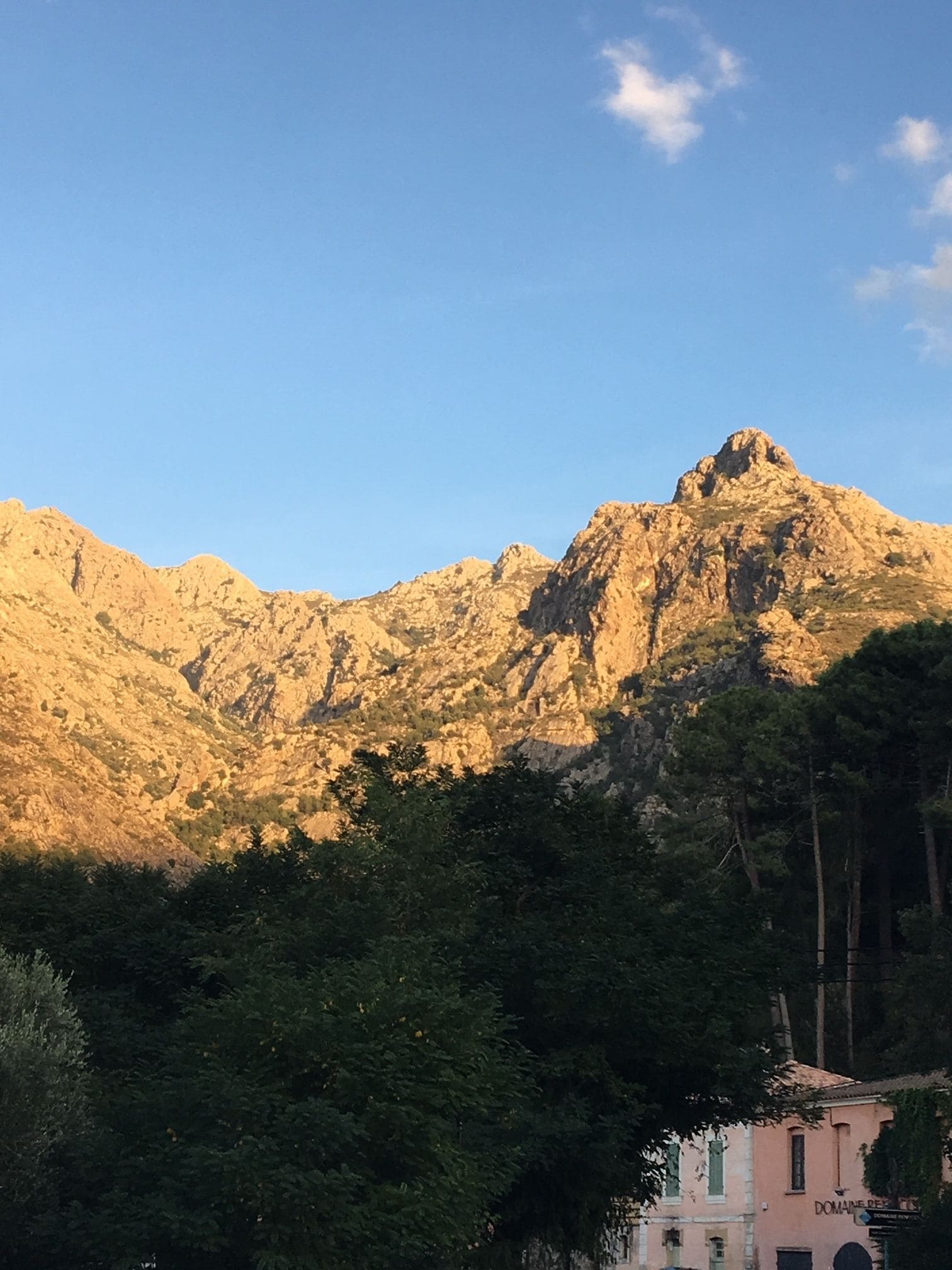 Cordillera montañosa con un edificio en primer plano.