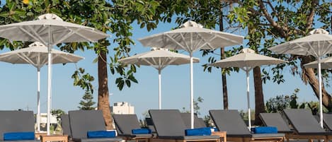 Piscine extérieure, parasols de plage, chaises longues