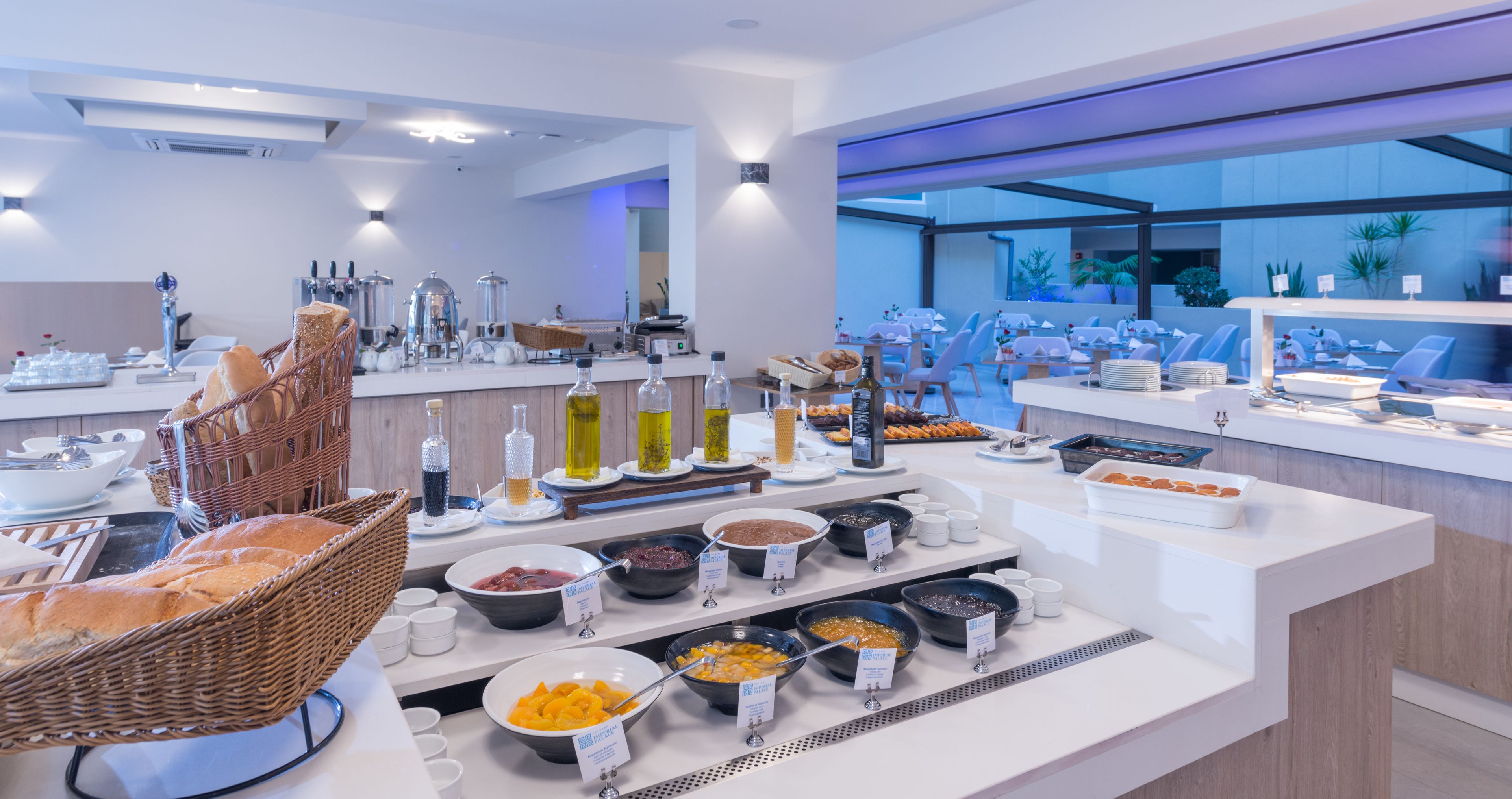 A buffet with various food items and a wicker basket with bread.