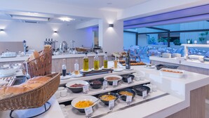 A buffet with various food items and a wicker basket with bread.