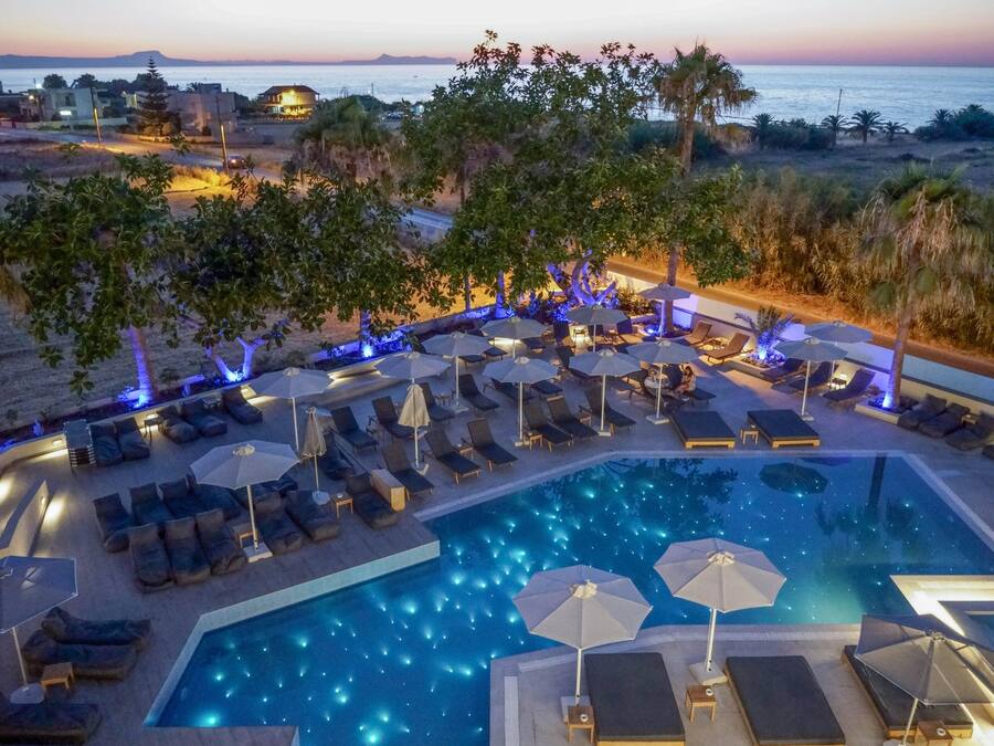 Una piscina al aire libre, sombrillas, sillones reclinables de piscina