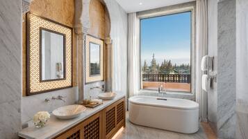 Un baño moderno con una bañera independiente, un espejo grande y un lavabo con pileta.