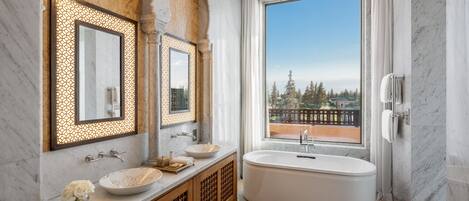 A modern bathroom with a freestanding bathtub, a large mirror, and a vanity with a bowl sink.