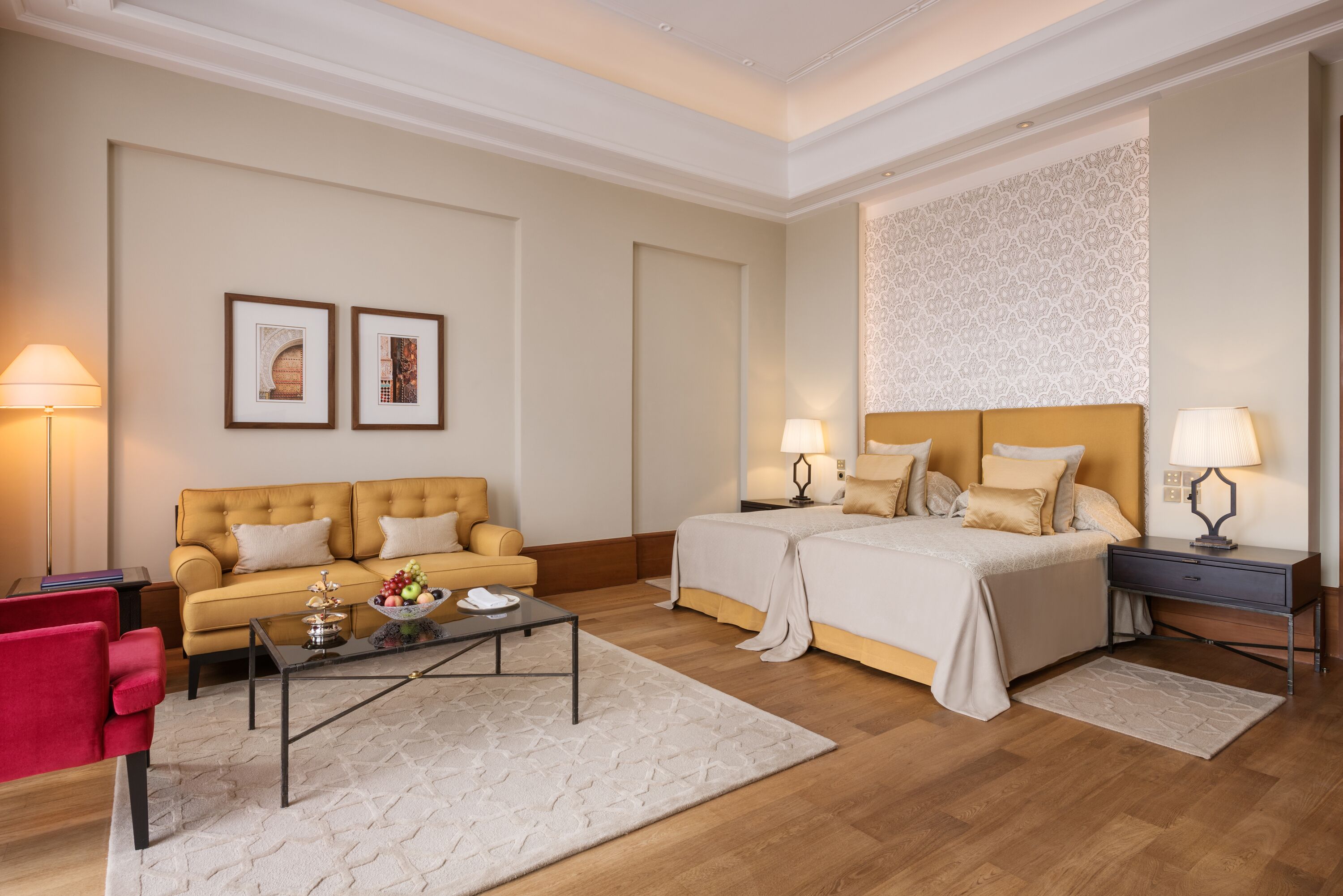 Une chambre d’hôtel avec un lit, un canapé, une table basse et un bureau.