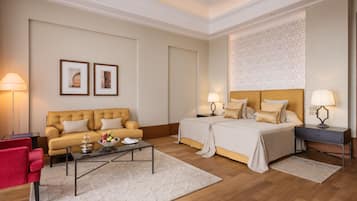 A hotel room with a bed, a sofa, a coffee table, and a desk.