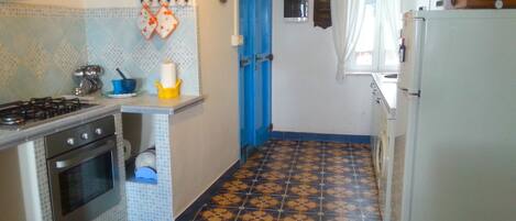 A compact kitchen with a gas stove, oven, and a refrigerator.