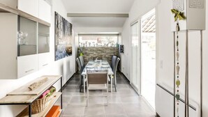 Een moderne keuken met een eethoek, met een stenen muur, een groot raam en uitzicht op het omliggende landschap.