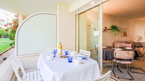 A dining area with a table set for two, a bottle of water, and a menu. - Le Cesarée by Interhome (Fréjus)