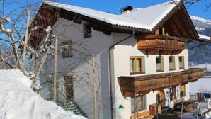 A chalet with a balcony, wooden exterior, and a snow-covered roof. - Herbert by Interhome (Kaltenbach)