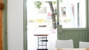 A bright room with a large window, a hanging light fixture, and a wooden table. - Mayhow Donghe - Hostel (Donghe)
