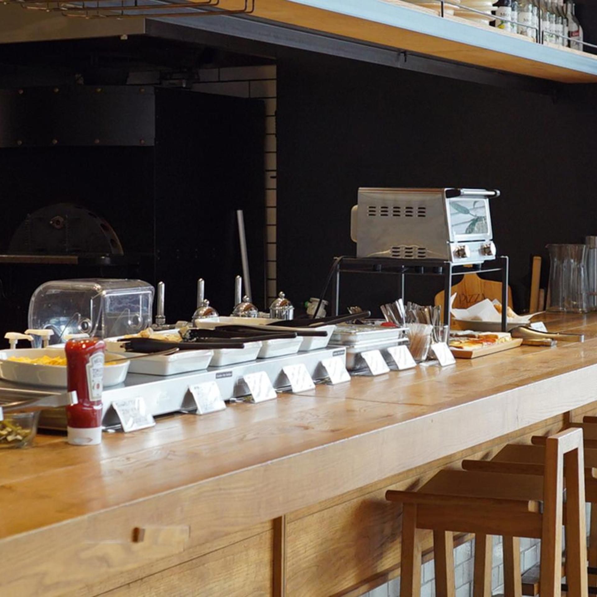 A kitchen counter with various cooking utensils, a grill, and a coffee machine.