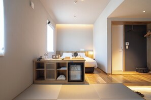 A compact hotel room with a bed, bedside table, and a small refrigerator. - Mascos Hotel (Masuda)