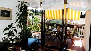 A balcony with a table, chairs, and a potted plant. - Apartmani Princ Hrvoje (Dubrovnik)