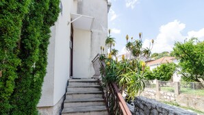 A staircase leading to a white building with a stone wall and metal railing. - Apartmani Princ Hrvoje (Dubrovnik)