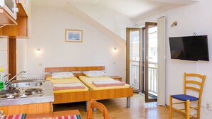 A bedroom with two beds, a TV, a sink, and a chair. - Apartmani Princ Hrvoje (Dubrovnik)