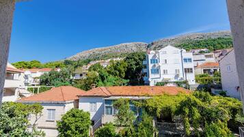 A residential area with houses, a hillside, and a clear blue sky.