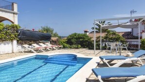 A swimming pool with lounge chairs and a covered seating area. - Puig Dels Daus by Interhome (Calonge)
