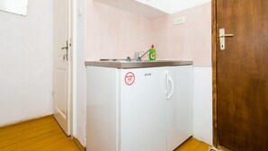 A compact kitchenette with a sink, a bottle of dish soap, and a refrigerator. - Rooms Kisic (Dubrovnik)