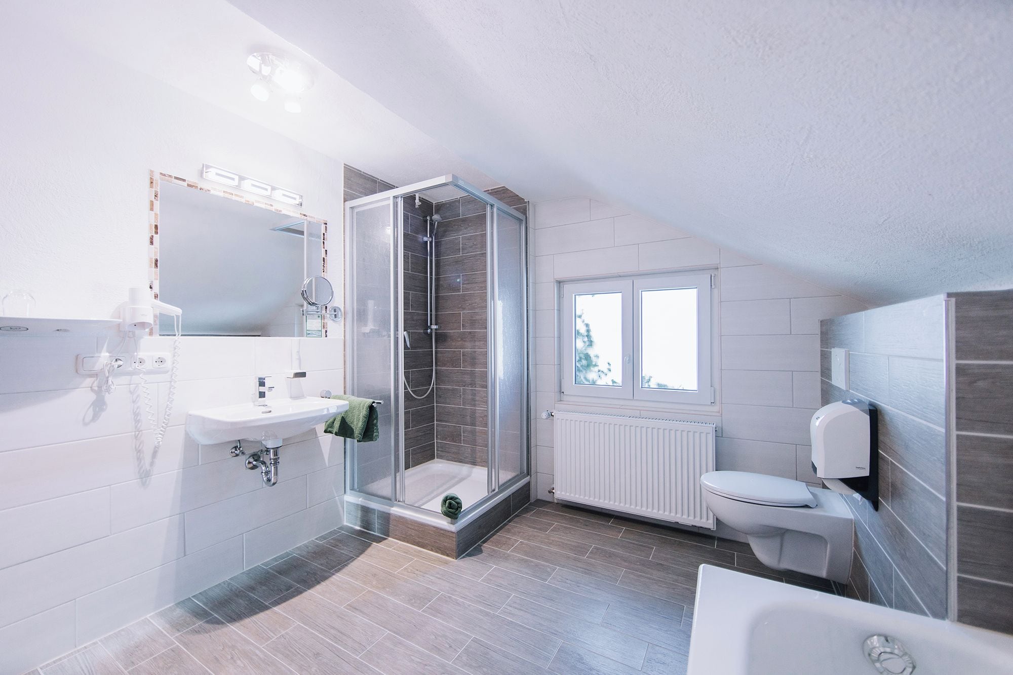 A modern bathroom with a shower, toilet, and sink.