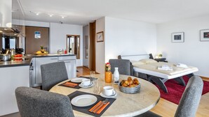 A modern hotel room with a dining area, kitchenette, and a bed. - Krokus Apt.T by Interhome (Wengen)