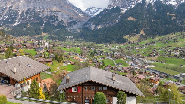 A mountain village with traditional wooden houses, a paved road, and a view of the surrounding mountains. - Chalet Shangri La by Interhome (Grindelwald)