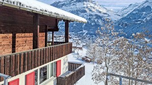 A wooden chalet with a balcony overlooking a snowy mountain landscape. - Chalet Shangri La by Interhome (Grindelwald)