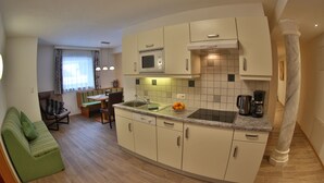A compact kitchen with a built-in microwave, a sink, and a coffee maker. - Apart Altamira (Ischgl)