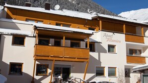 A multi-story building with a sign reading "Apart Altamira." It features wooden balconies and a snowy mountain backdrop. - Apart Altamira (Ischgl)
