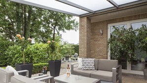 An outdoor patio area with seating, a table, and potted plants. - Villa Eltins (Bad Bentheim)