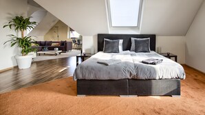 A modern bedroom with a large bed, a potted plant, and a skylight. - Villa Eltins (Bad Bentheim)