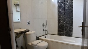 Une salle de bain avec des toilettes, un lavabo et une baignoire.