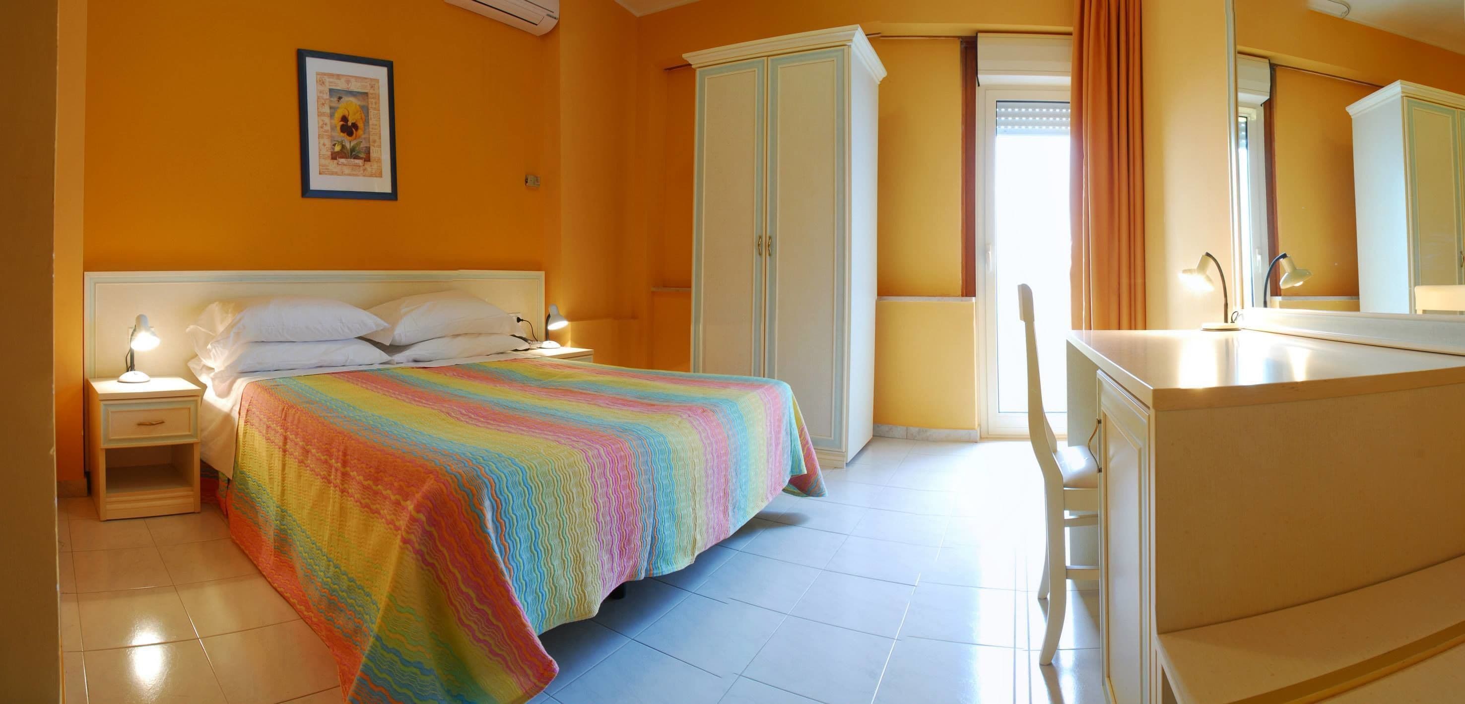 Un dormitorio con cama, mesitas de noche, cómoda y armario.